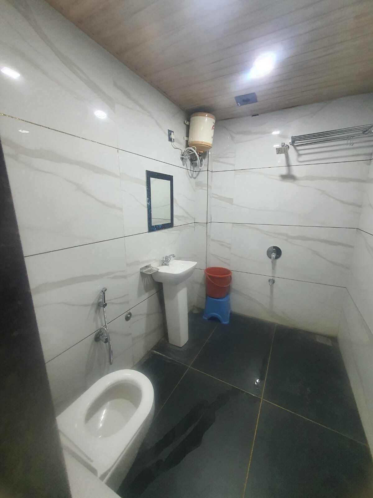 Un baño pequeño con azulejos, un inodoro, un lavabo y una ducha.