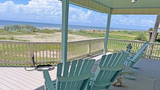A covered deck with Adirondack chairs and a view of the beach. - Faye DoDo - Beachfront - Island Realty (Grand Isle)