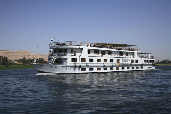 A large, multi-deck river cruise ship with balconies and a name "IBEROTEL AMARA" visible.