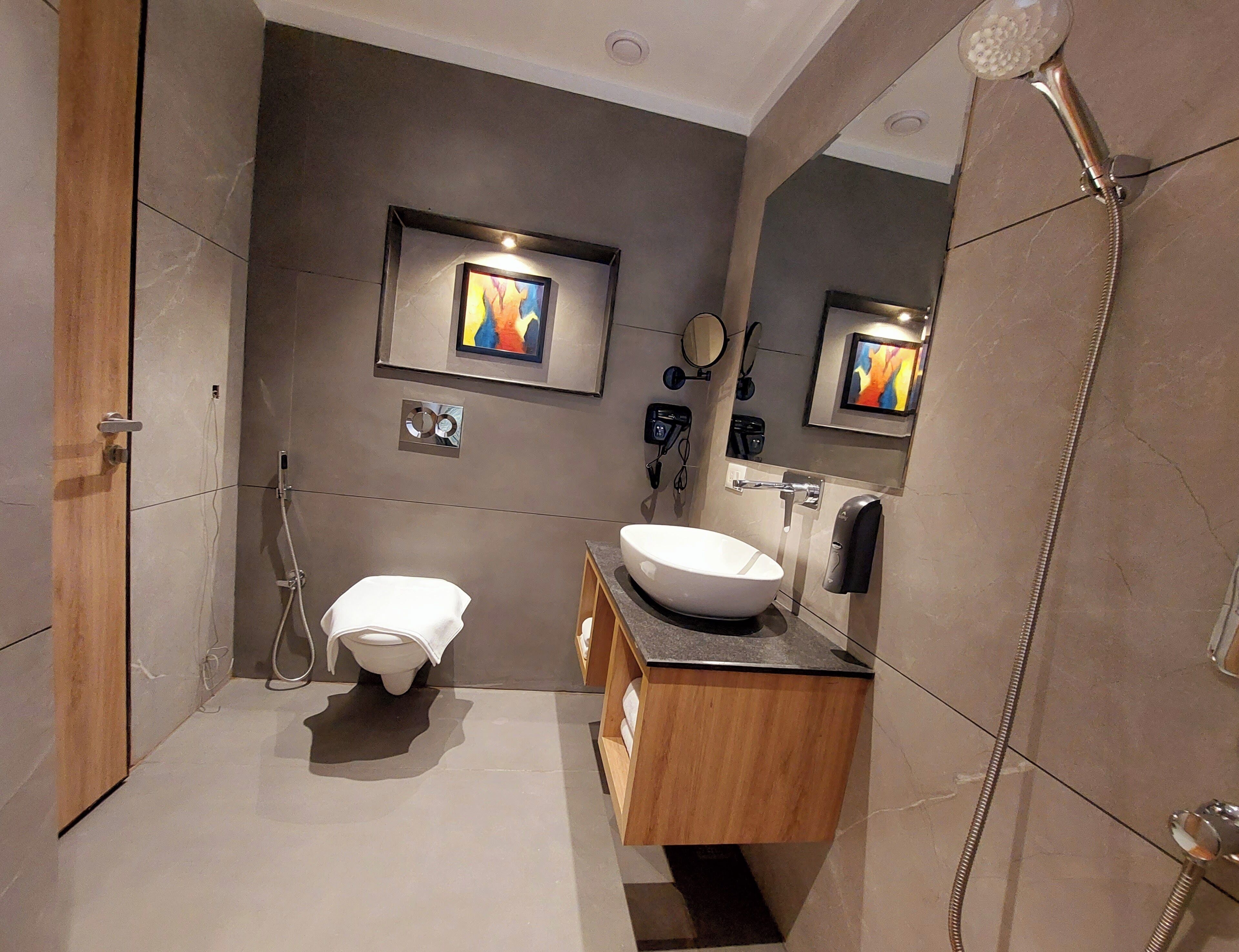 A modern bathroom with a toilet, sink, and shower.