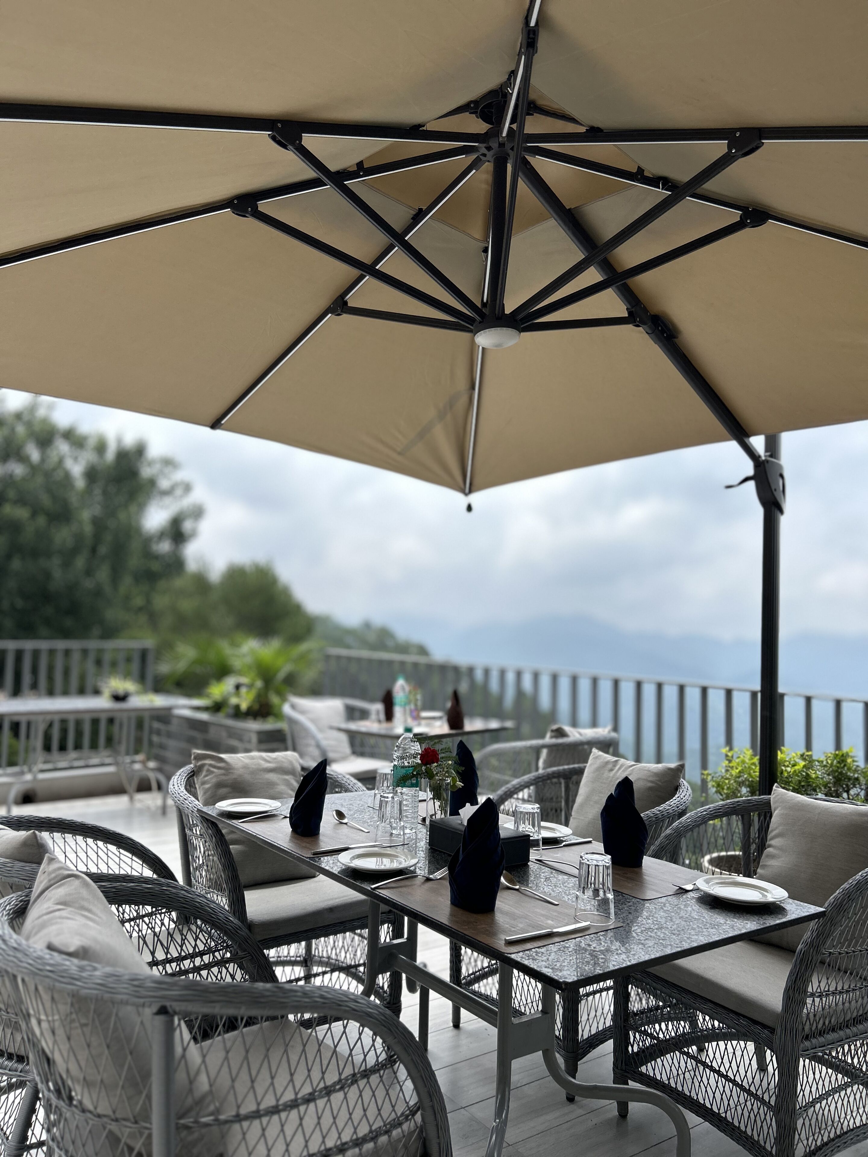 A dining area with outdoor seating, tables, and umbrellas.