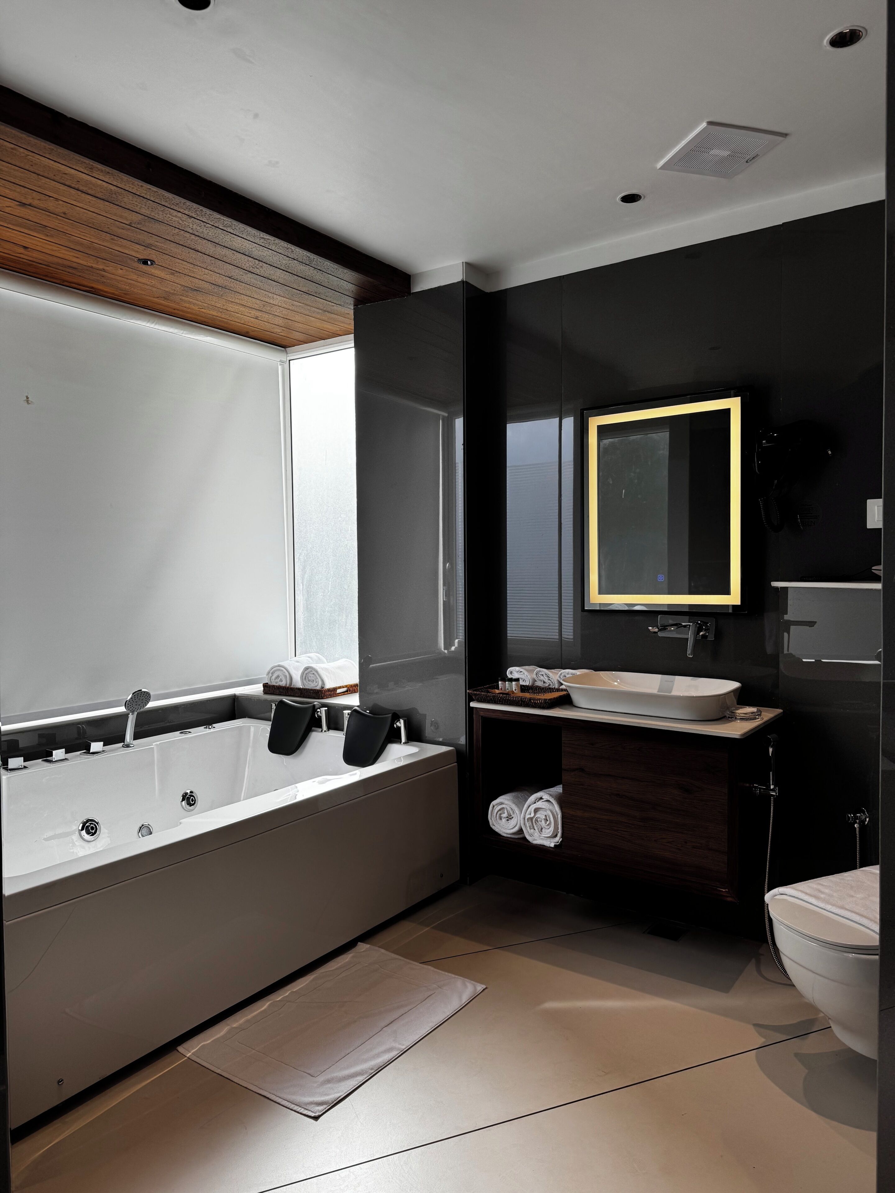 Un baño moderno con una bañera, un lavabo, un espejo y un inodoro.