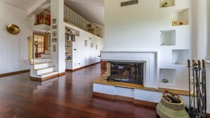 A spacious living area with a fireplace, wooden flooring, a staircase with a railing, and a bookshelf. - Apartment in Recco with 1 bedrooms sleeps 4 (Recco)