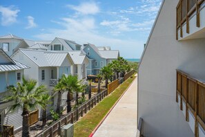 A coastal residential area with houses, a sidewalk, and a view of the ocean. - La Mirage Condo 206 Beachfront Resort Condominiums with Private Boardwalk to Beach (Port Aransas)