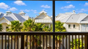 A row of white buildings with metal roofs and palm trees in front. - La Mirage Condo 206 Beachfront Resort Condominiums with Private Boardwalk to Beach (Port Aransas)