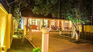 Ein Innenhof mit überdachter Sitzgelegenheit, Blumentöpfen und einem Pool.