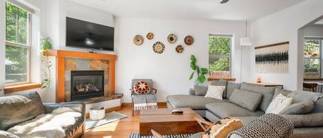 A living room with a fireplace, a sofa, a coffee table, and a television.