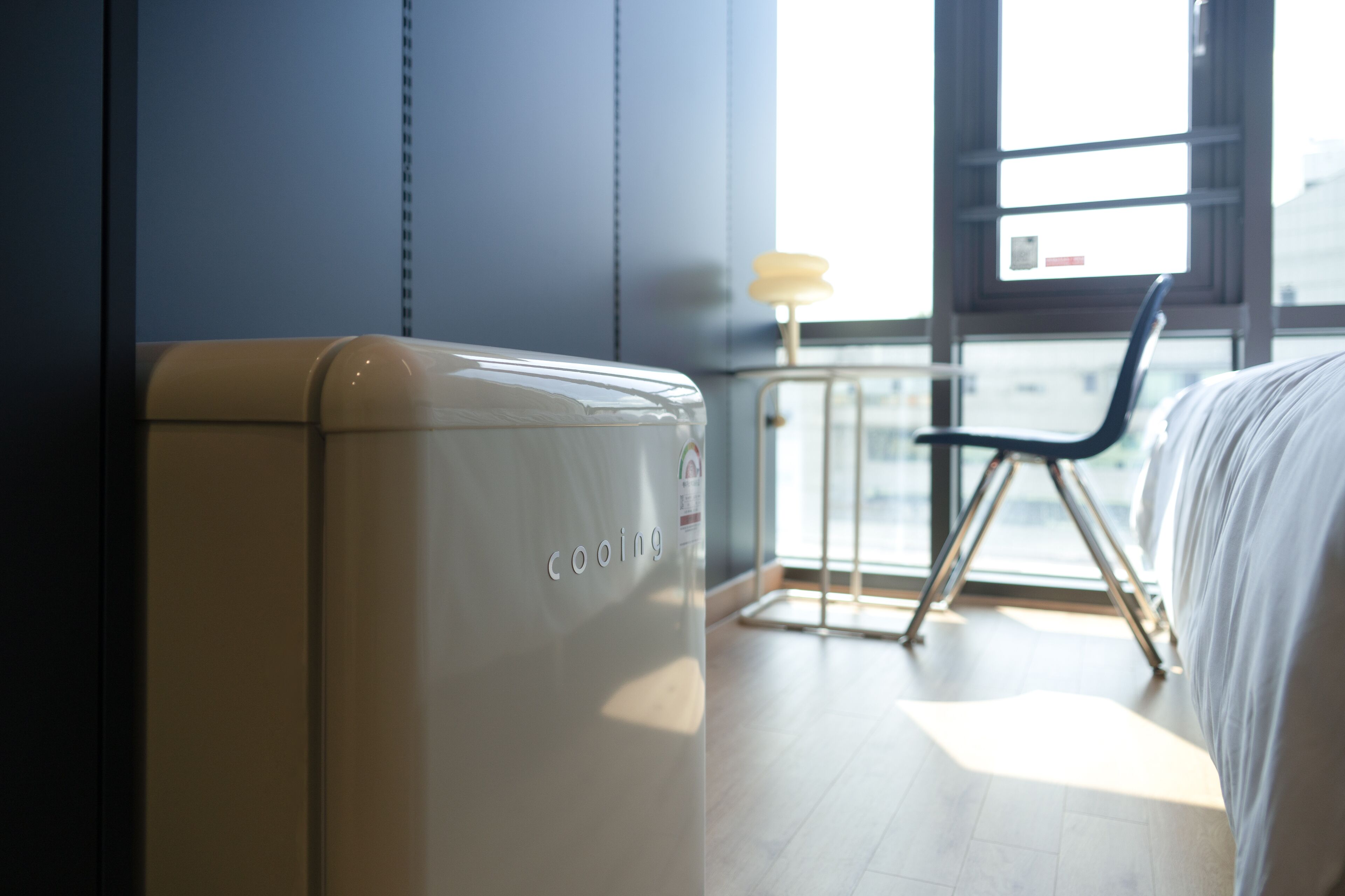 Una habitación de hotel moderna con cama, una silla y un amplio ventanal.