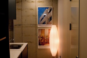 A bathroom with a sink, a mirror, and a wall-mounted light fixture.