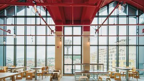 Une salle à manger spacieuse, dotée de hauts plafonds et de grandes fenêtres offrant une vue sur la ville.