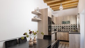 A modern kitchen with wooden cabinets, a black countertop, and a patterned backsplash. - Antica Casa Dei Nonni (Rhodes)