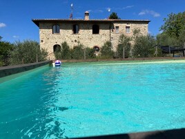 Una piscina al aire libre de temporada, sombrillas