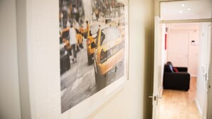 Un pasillo con una fotografía enmarcada de un taxi amarillo en la pared.
