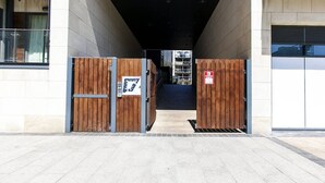 A building entrance with a wooden gate and a fire safety sign. - Grande Central Sandyford (Dublin)
