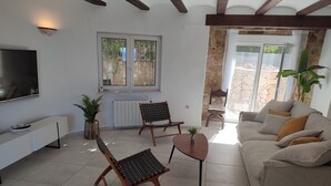 A living room with a sofa, two armchairs, a coffee table, a TV, and a window with a view of the outside. - Beautiful Villa with gorgeous seaviews, close to the centre andbeaches of Denia. (Denia)