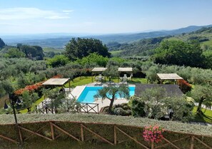 Una piscina rodeada de abundante vegetación y vistas a colinas distantes.