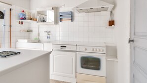 A modern kitchen with white cabinetry, a built-in oven, and a microwave.