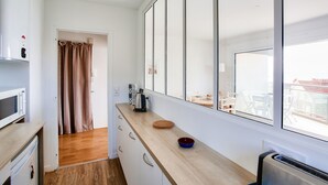 A compact kitchen with a microwave, kettle, and a small bowl on the counter. - Holiday with sea view in Pléneuf-Val-André (Pléneuf-Val-André)