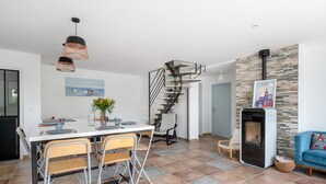 Una sala moderna con comedor, chimenea y escalera en espiral.