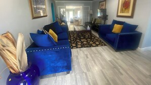 A living room with two blue sofas, a coffee table, and a patterned rug. - Private Pool, Gazebo, Firepit, and Hot Tub. Optional Guest Suite (Lake Worth)