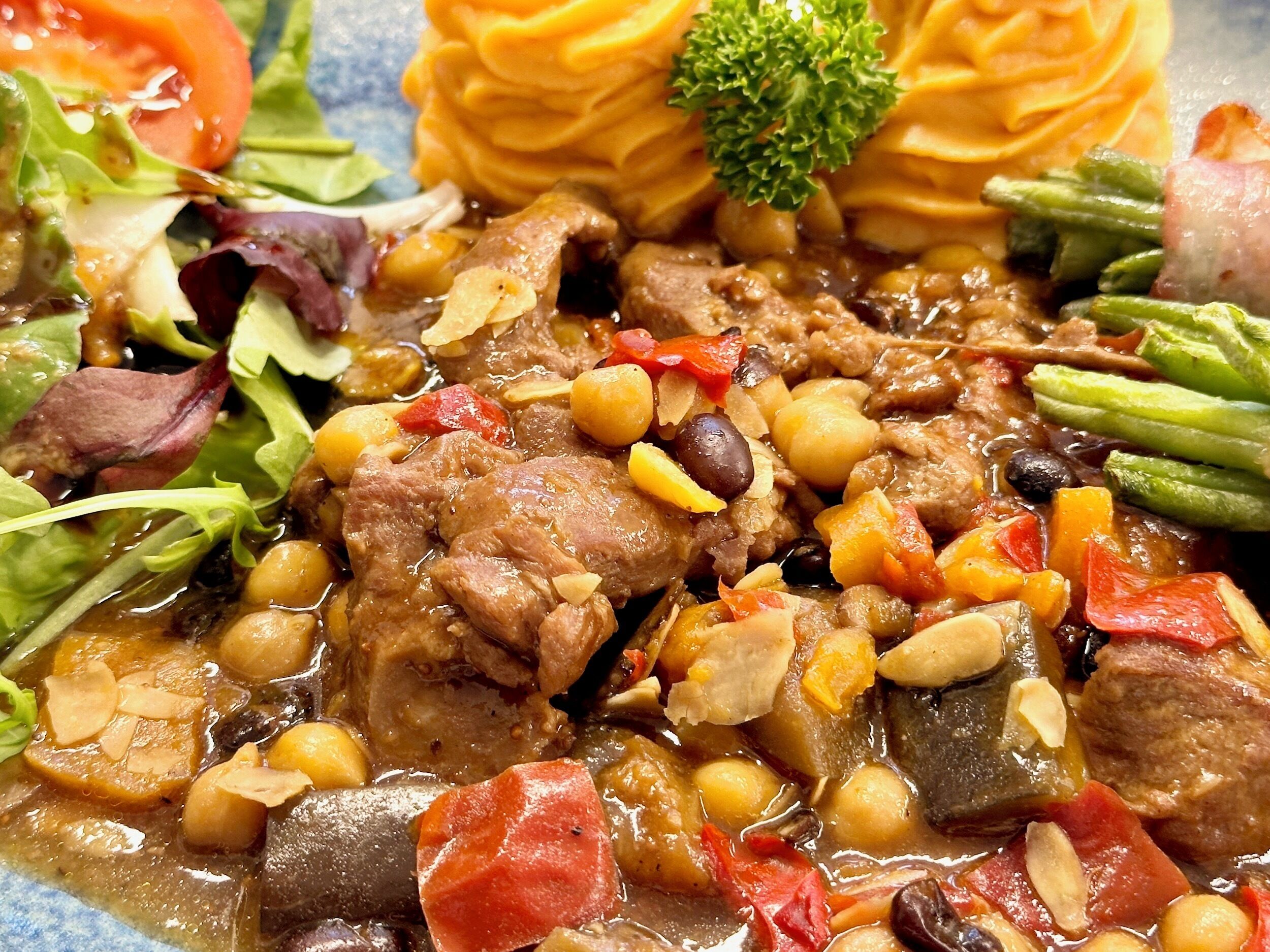 Uma refeição com diversos vegetais, carne e um toque de salsa.