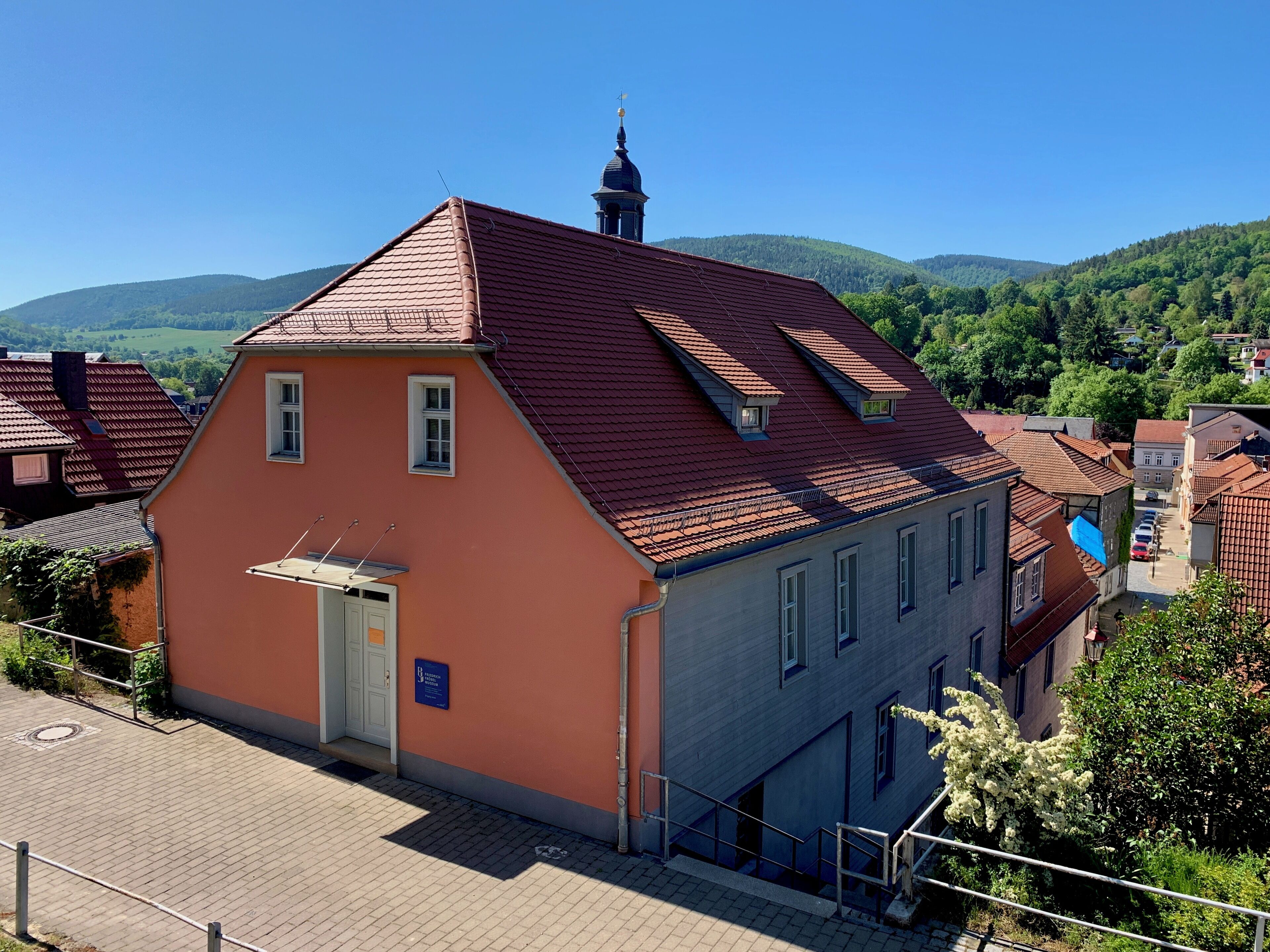A building with a red-tiled roof, a small window, and a door.
