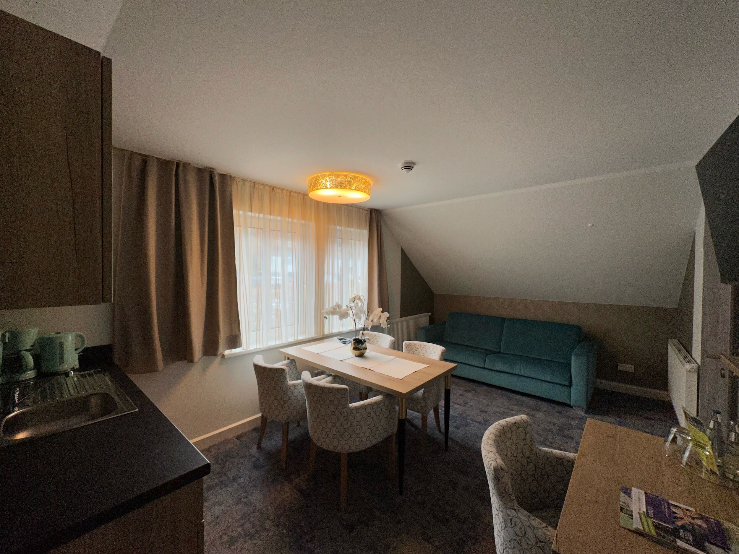 Un espace de vie compact comprenant un coin repas, une kitchenette et un canapé.