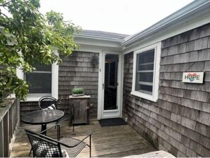 Enjoy a peaceful retreat with an outdoor space featuring a round table, two chairs, and a potted plant.