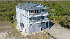 Une maison à deux étages dotée d’un balcon, d’un porche abrité et offrant une vue sur le paysage environnant.