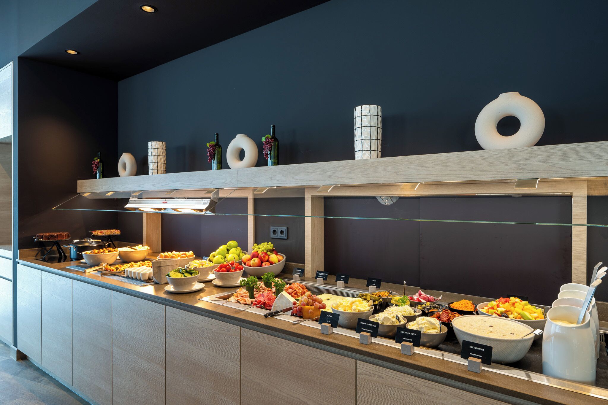 A buffet with various food items and a glass display case.