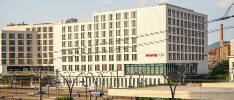 Un hôtel InterCity moderne, doté d’une grande façade en verre, de plusieurs étages et d’une entrée imposante.