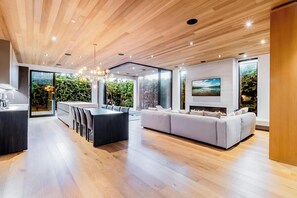 A modern interior with a wooden ceiling, a dining area, a sofa, and a fireplace.