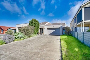 A modern two-story house with a garage, a driveway, and a well-maintained lawn.