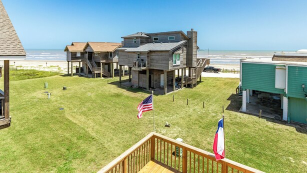 Une propriété située en bord de mer, comprenant plusieurs constructions en bois, un drapeau et offrant une vue sur l’océan.
