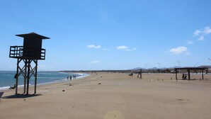 Une plage avec une tour de surveillance, du sable et un ciel dégagé.