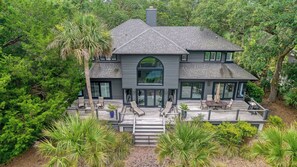 A two-story house with a large deck, surrounded by lush greenery. - New Listing in popular neighborhood (Kiawah Island)