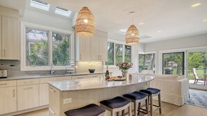 A modern kitchen with a large island, pendant lights, and a view of the outdoors. - New Listing in popular neighborhood (Kiawah Island)
