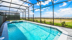 Una piscina amb una vista clara de l'entorn, incloent una tanca i edificis allunyats.