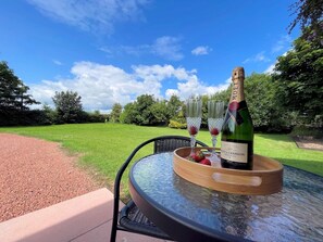 A table with a bottle of Moët & Chandon champagne, two glasses, and a bowl of strawberries. - Spectacular 7BR House Hot Tub and Gardens in Gretna - Pass the Keys (Gretna Green)
