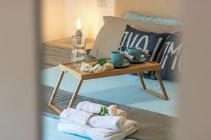 Un plateau de petit-déjeuner soigneusement préparé, avec un verre, deux tasses et une assiette de nourriture, posé sur une table en bois.