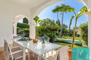 Enjoy al fresco dining amidst lush gardens and a serene pool view.