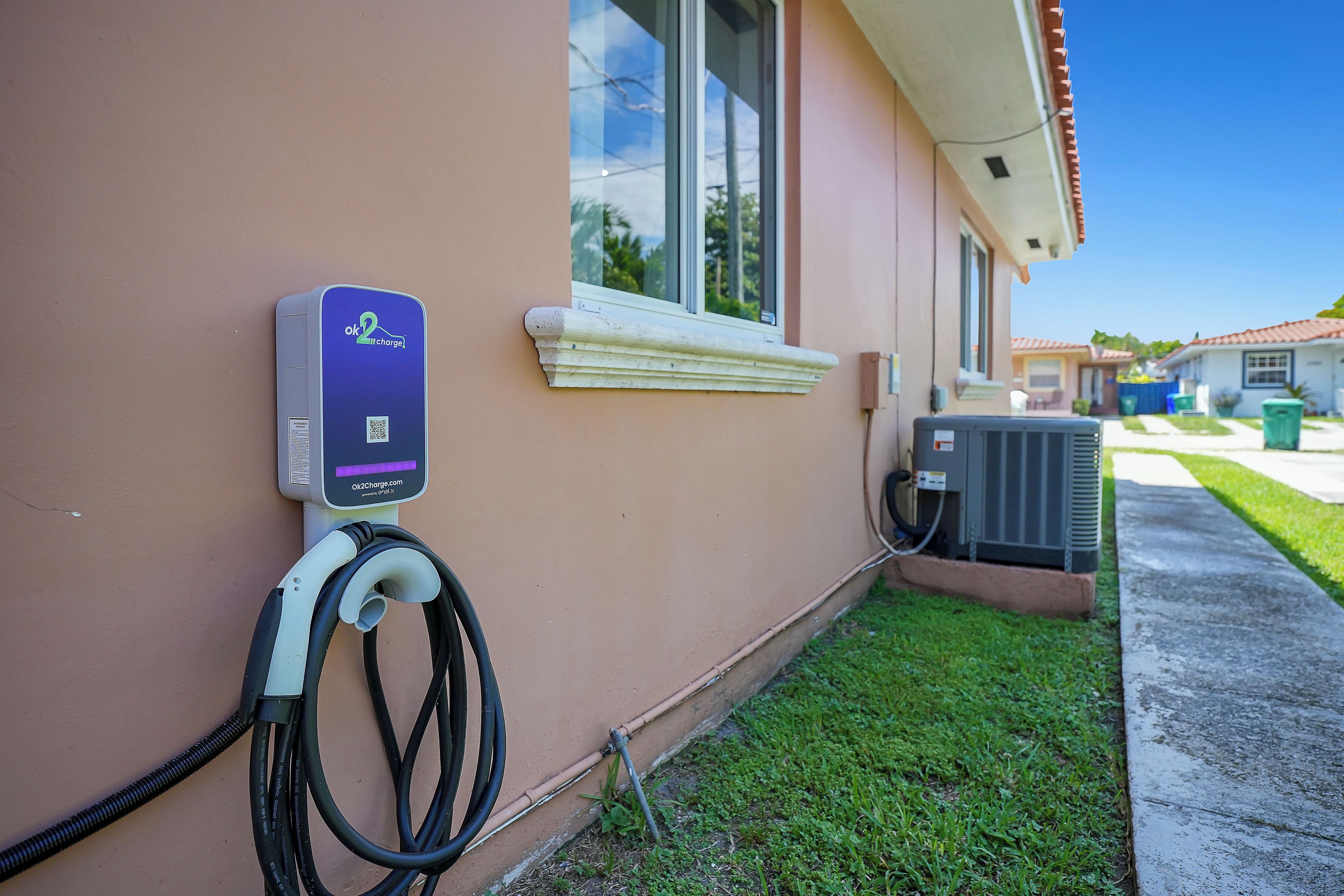 Een laadstation voor elektrische voertuigen, bevestigd aan de buitenmuur van een gebouw.