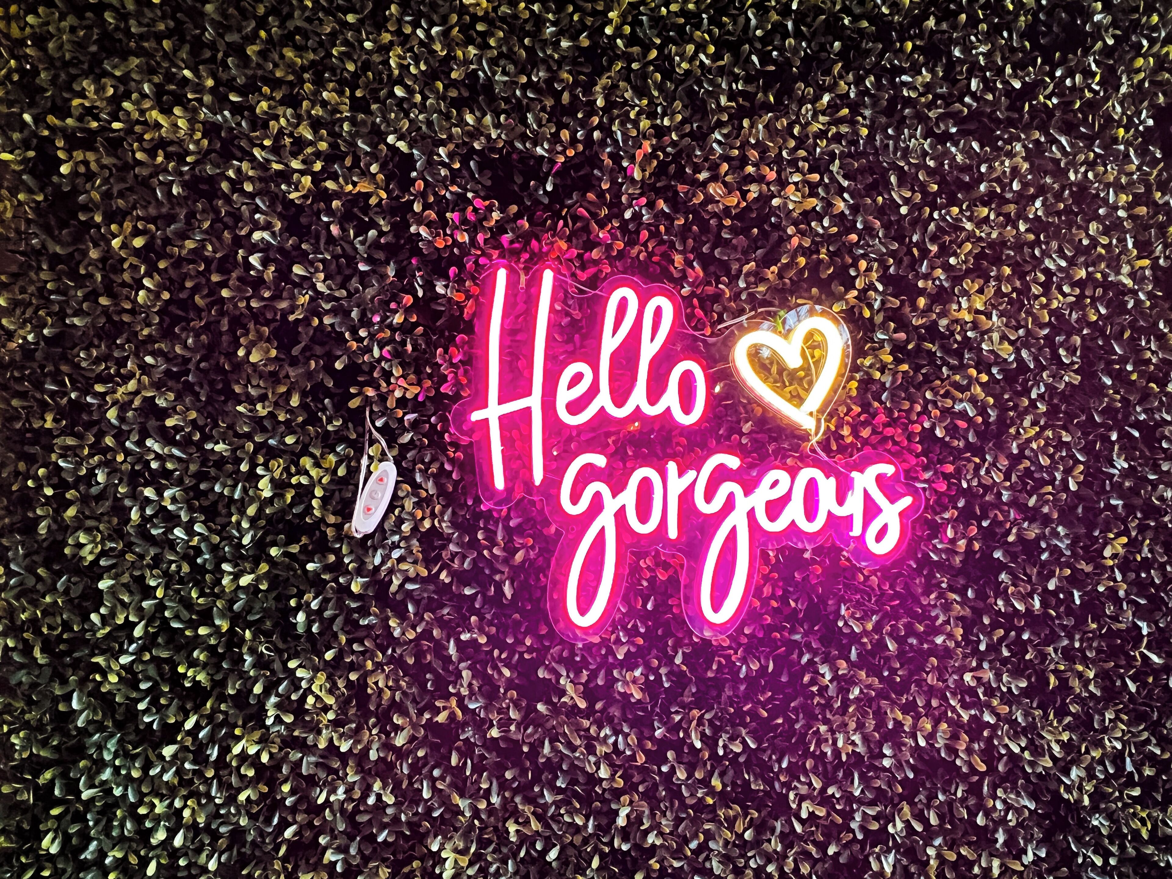 Een neonbord met de tekst 'Hello gorgeous' en een hartsymbool.