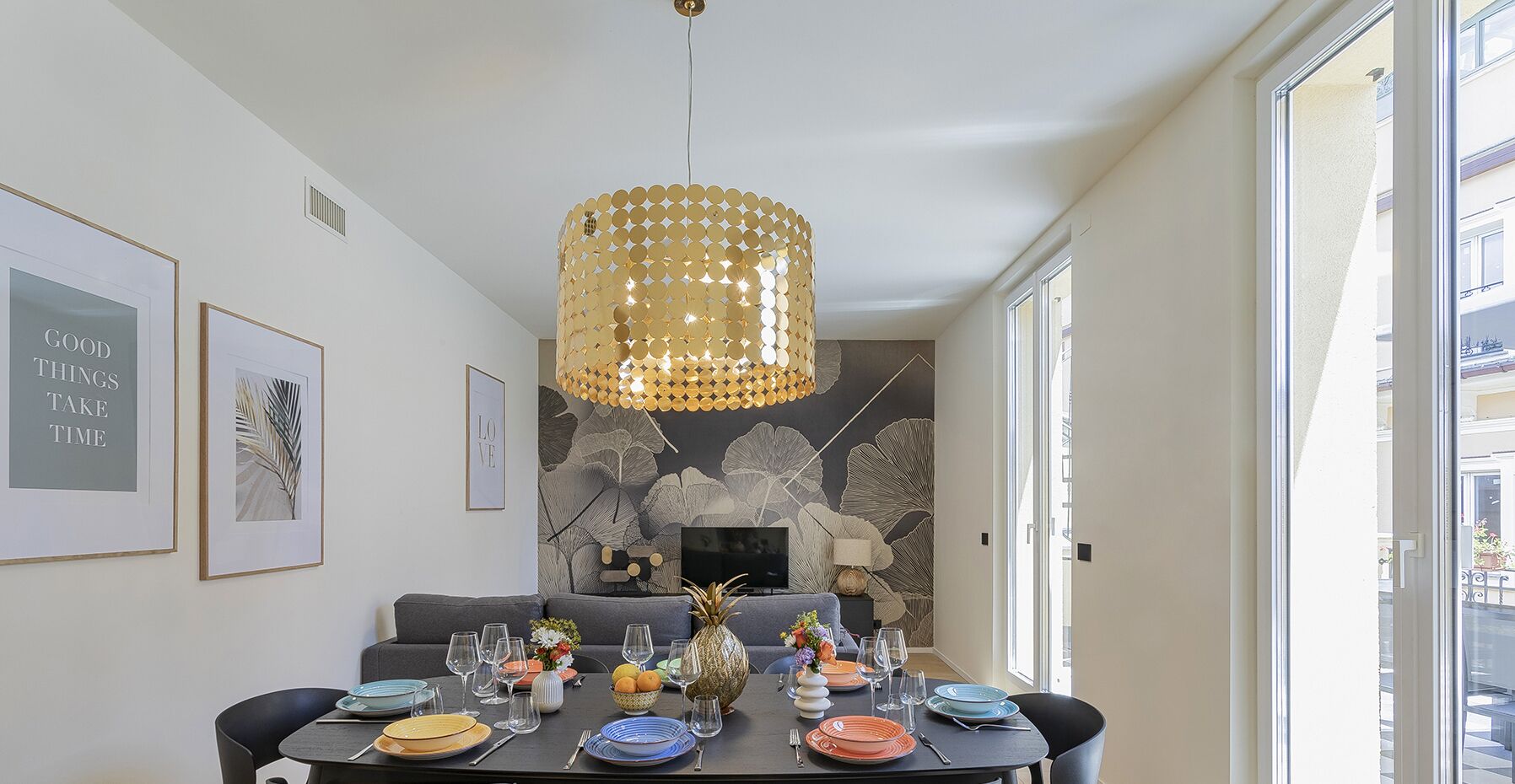 Ein Essbereich mit einer Chandelier, gerahmten Kunstwerken und einem Kamin.
