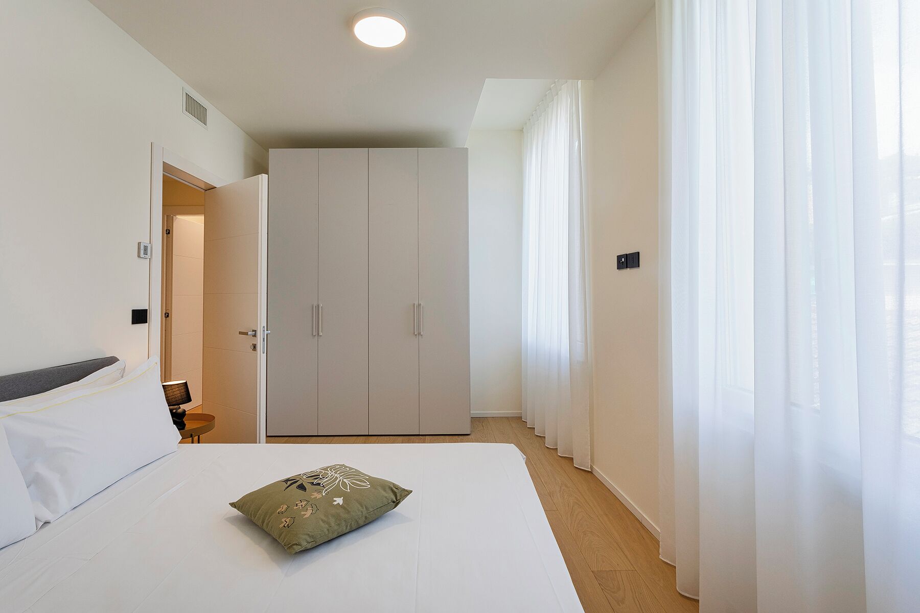 Una camera d'albergo con un letto, un armadio e un bagno.