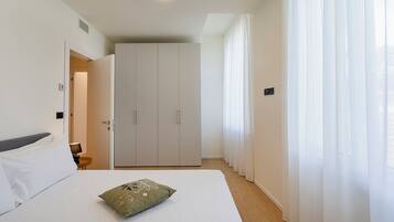 Una camera d'albergo con un letto, un armadio e un bagno.