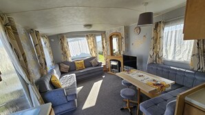 A compact living space with a sofa, a dining table, and a fireplace.