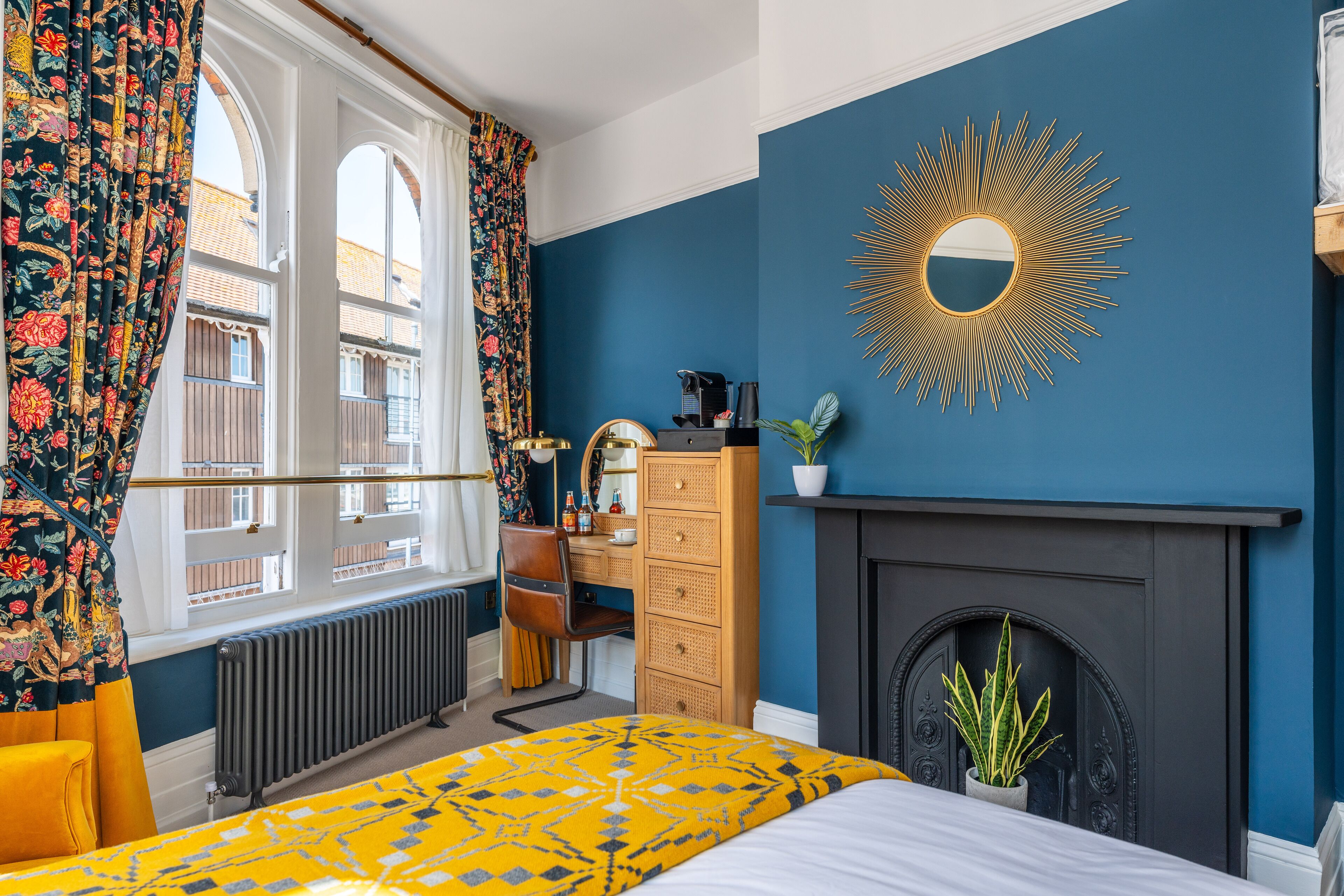 Ein Schlafzimmer mit Bett, Kommode und Kamin.