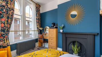 Ein Schlafzimmer mit Bett, Kommode und Kamin.