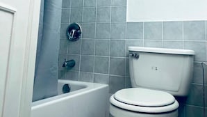 A bathroom with a white toilet and a bathtub. - Cozy Central 1-bed Apartment in Kingston (Kingston)